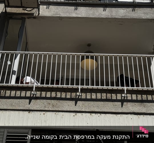 מרפסת עם מעקה מתכת ולמעלה מנורה